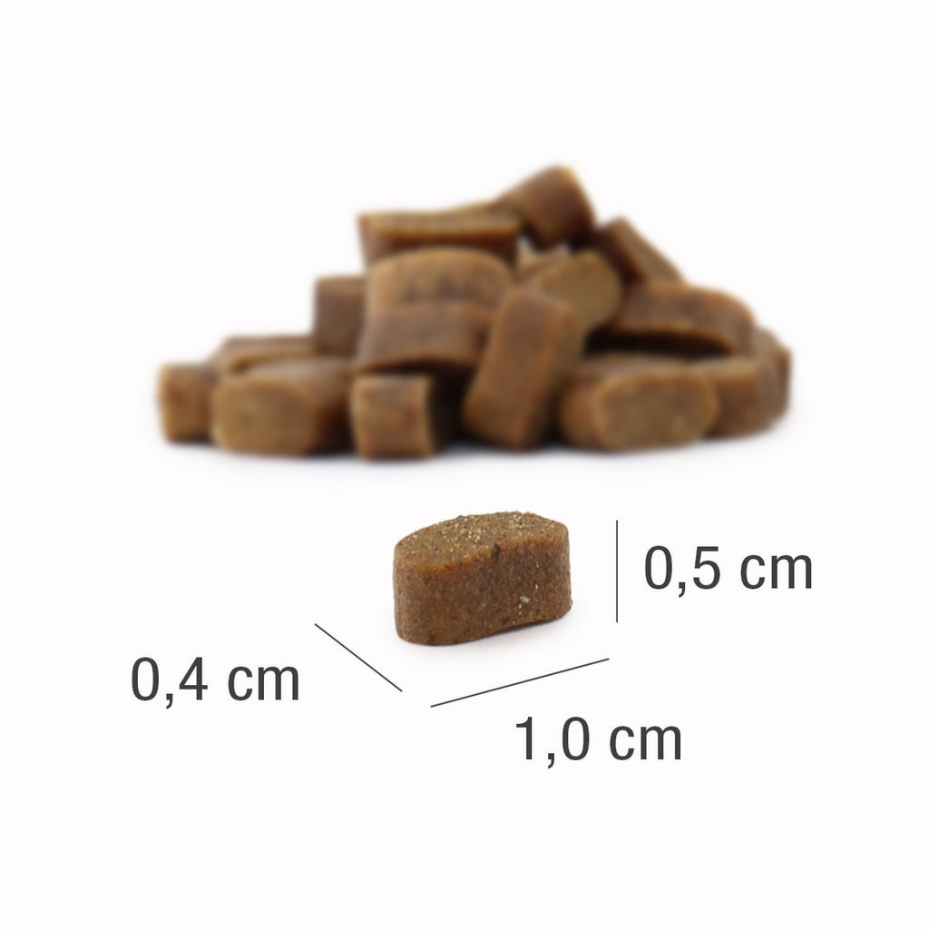 Pred kupom enakih prigrizkov na beli podlagi je prikazan majhen, rjav, podolgovat priboljšek PLATINUM Adult Iberico, Suha Hrana za Pse (1,0 cm x 0,5 cm x 0,4 cm).
